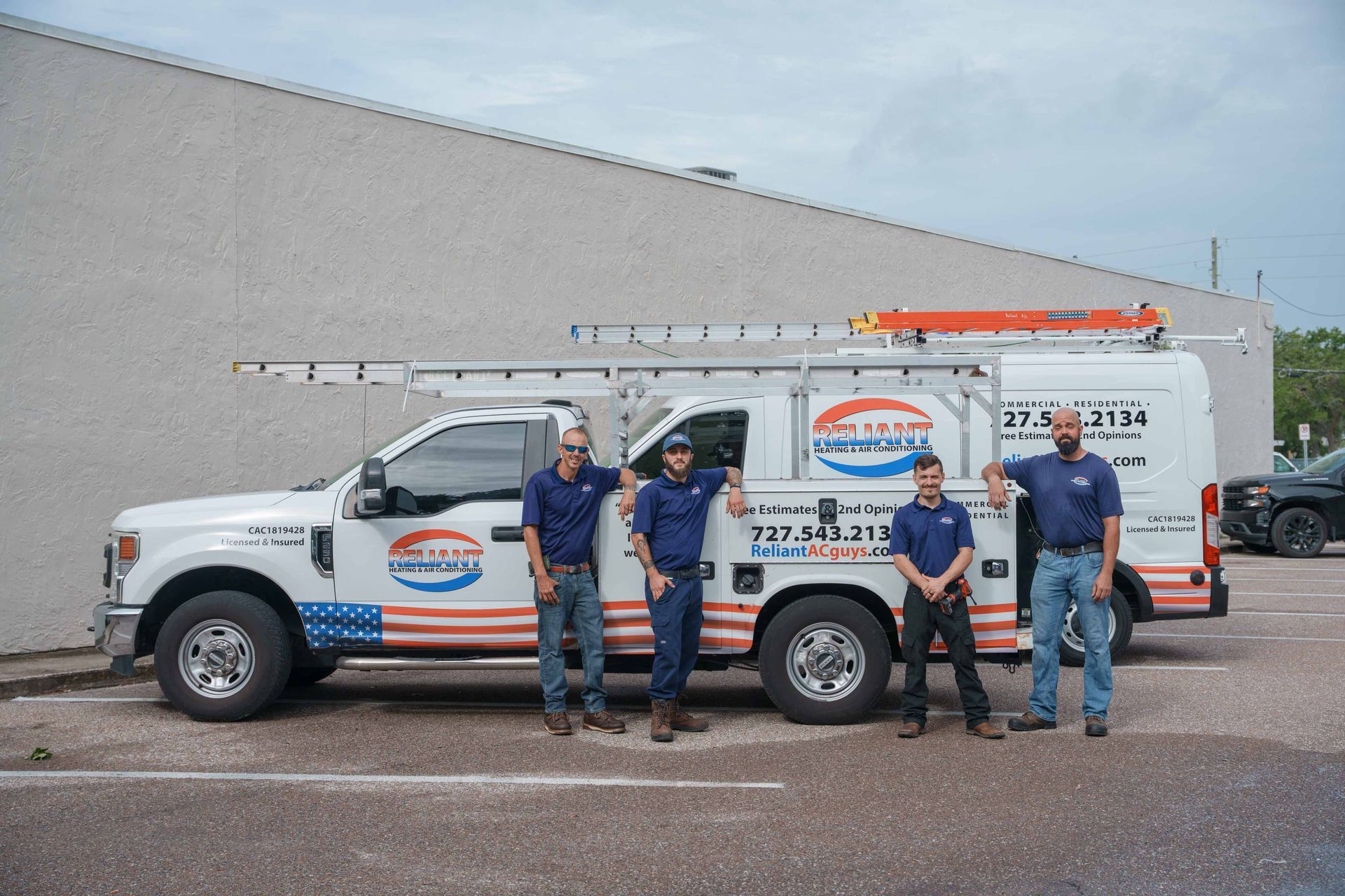 A group of Reliant Heating & Air Conditioning technician are standing in front of a truck.