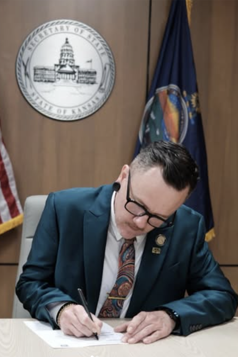 Senator Silas Miller signing paperwork at the Kansas Secretary of State office
