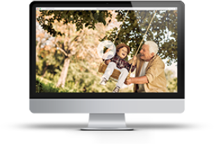 Desktop monitor showing a smiling family outdoors under a tree
