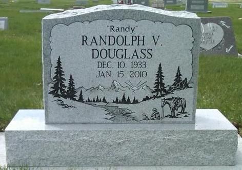 Gravestone for Randy Randolph V. Douglass with pine tree engraving in a cemetery