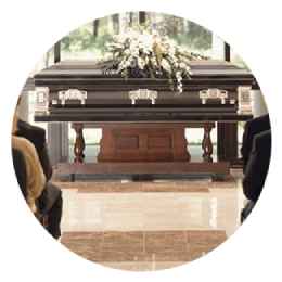 Closed casket with white floral arrangement in a bright funeral chapel