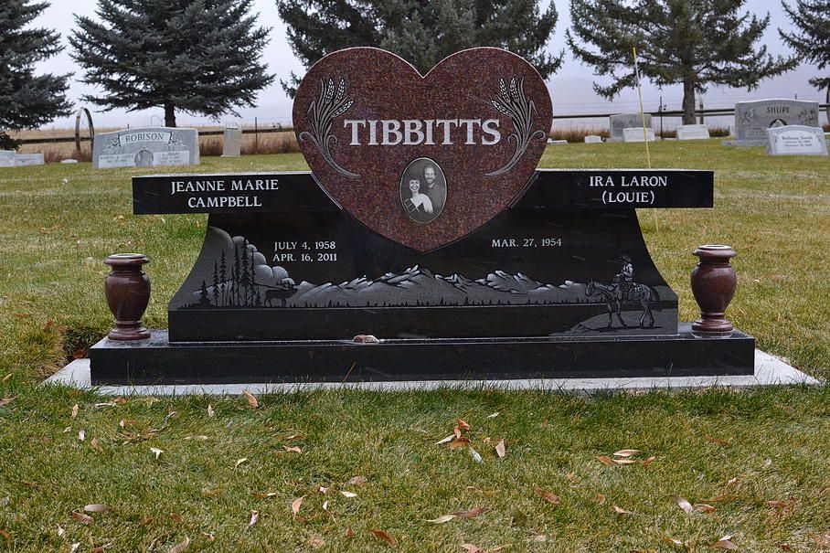 Tibbits memorial headstone with heart-shaped plaque in a cemetery, flanked by smaller name plaques.