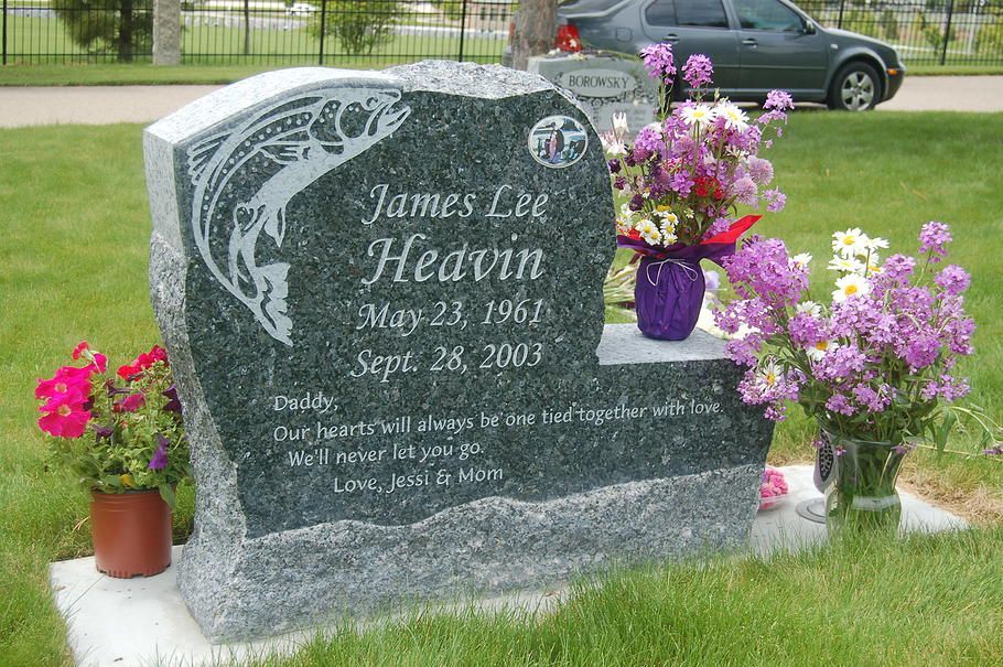 Gravestone with flowers and potted plants in a cemetery, honoring James Headon, surrounded by grass.