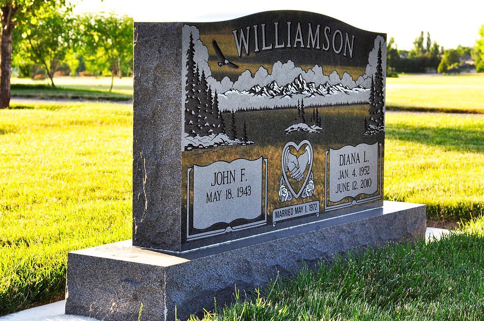 Granite gravestone with “WILLIAMSON” engraved, set in a sunny green cemetery lawn.