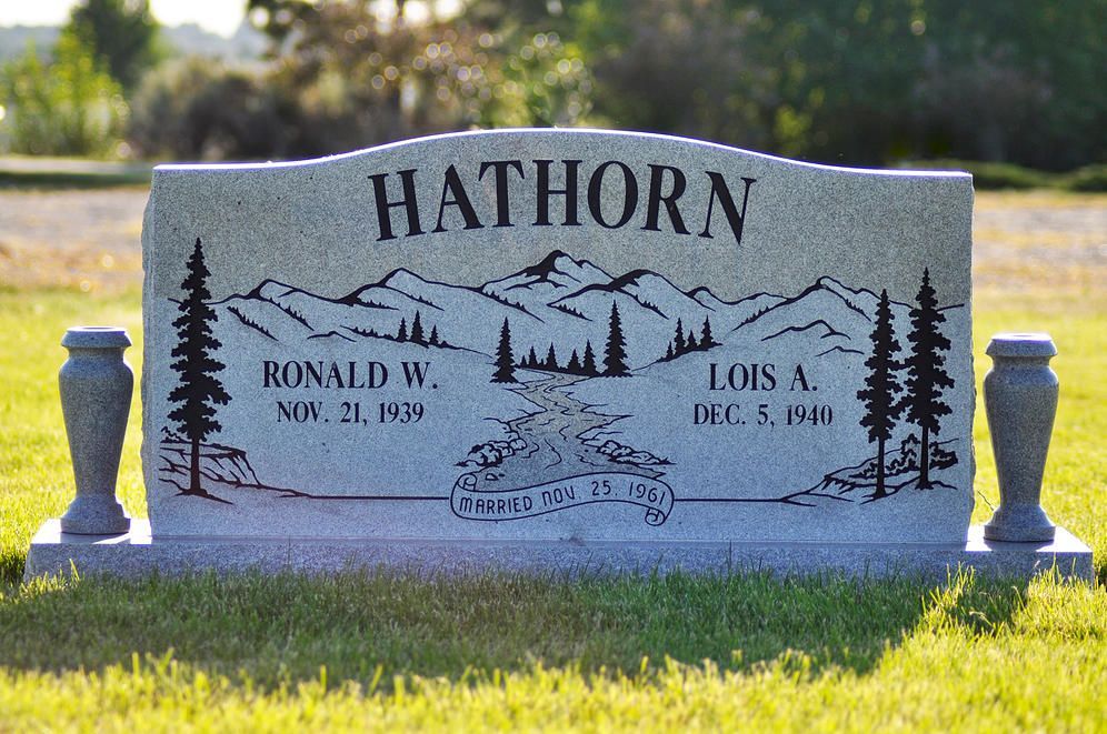 Hathorn family gravestone in a grassy cemetery, with trees and decorative carvings.