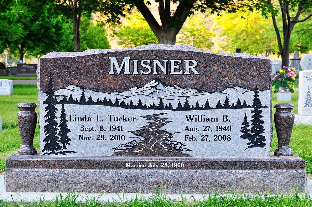 Misner family gravestone with mountain scene in a cemetery, engraved with two names and dates