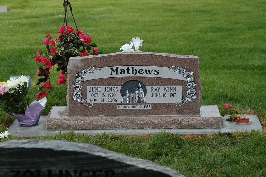 Mathews gravestone with pink flowers in a grassy cemetery