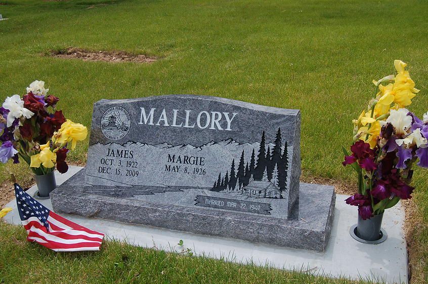 Mallory family gravestone with flowers and a U.S. flag on a grassy lawn