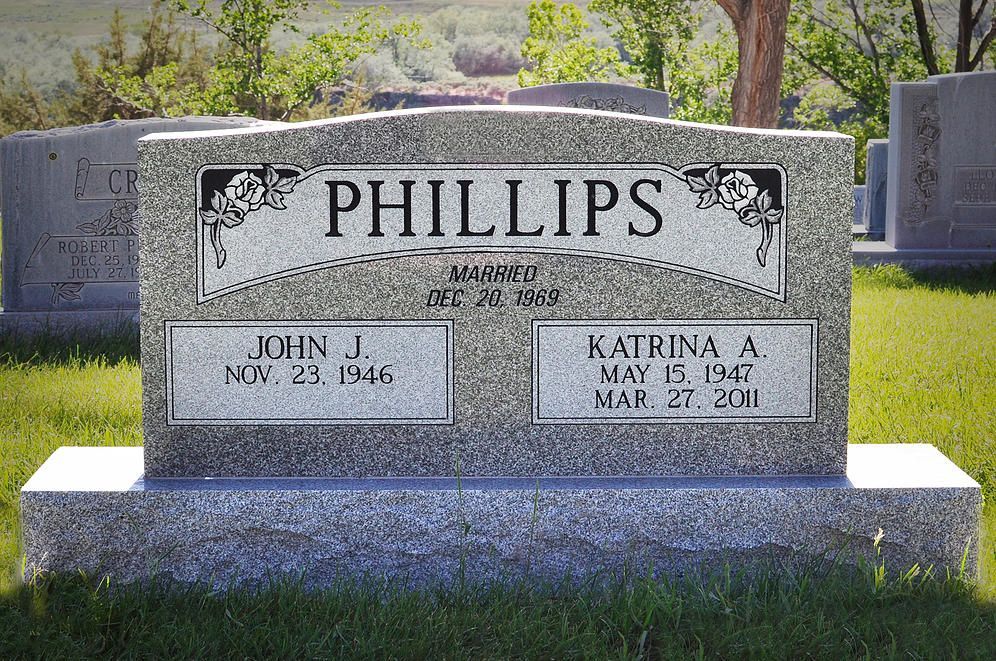 Phillips family gravestone in a cemetery with engraved names and dates on a gray headstone.