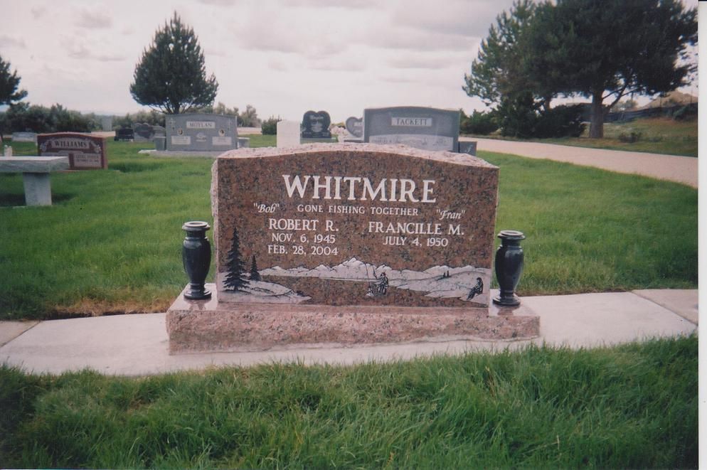 Whitmire cemetery entrance sign with gravestones and green grass beside a paved path