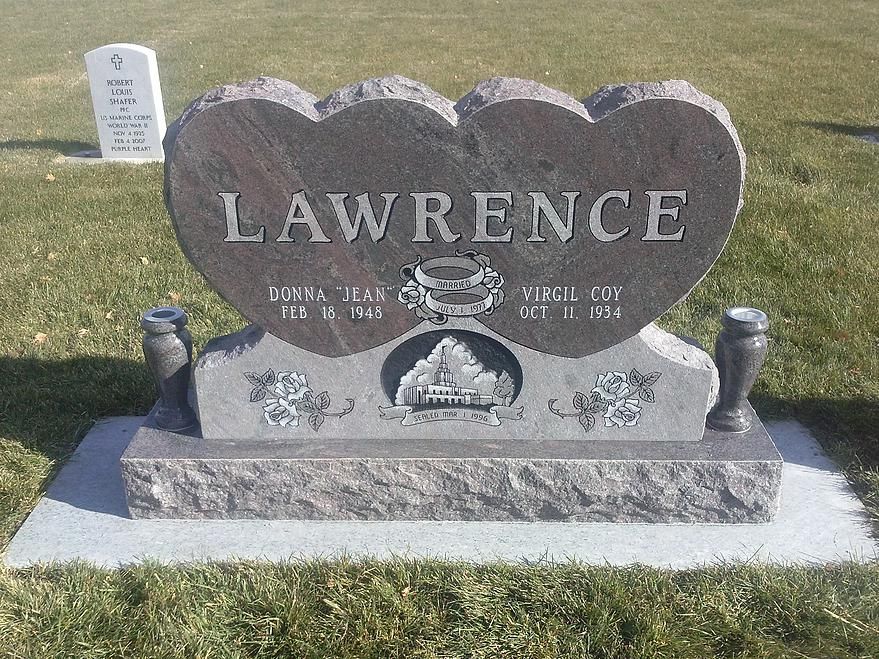 Gray gravestone with “LAWRENCE” engraved, set on a grassy cemetery plot.