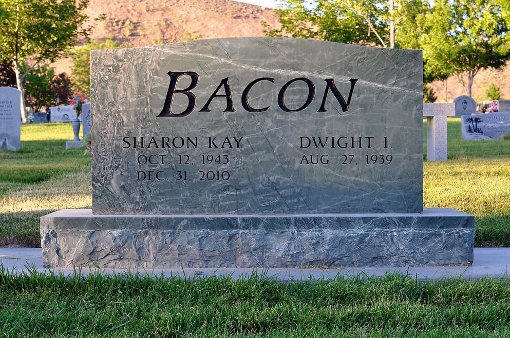 Bacon family gravestone in a cemetery, with large engraved surname and two names below.