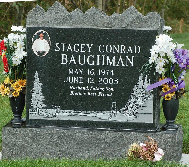 Black granite memorial headstone with flowers for Stacey Conrad Baughman in a cemetery
