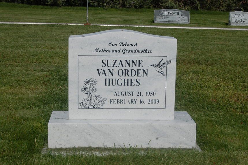 White memorial gravestone in a grassy cemetery with engraved name and dates.