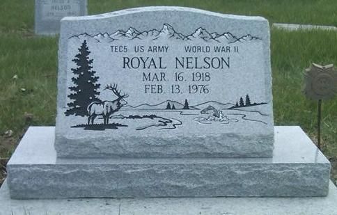 Gray gravestone for Royal Nelson with engraved tree and deer scene in a cemetery