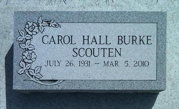 Gray gravestone plaque with floral carving reading “Carol Hall Burke Scouten, July 26, 1931 – Mar. 5, 2010”