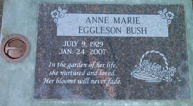 Gray memorial plaque for Anne Marie Eggleson Bush with dates and engraved flowers in a stone setting