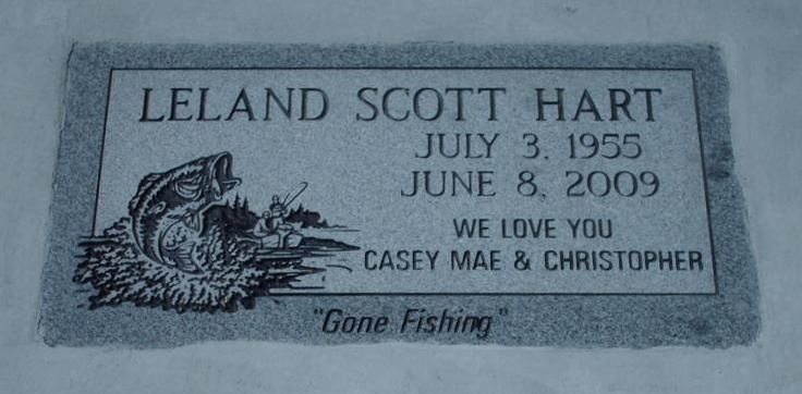 Gray memorial stone engraved “Leland Scott Hart,” dates July 3, 1955–June 8, 2009, with fish and “Gone Fishing”