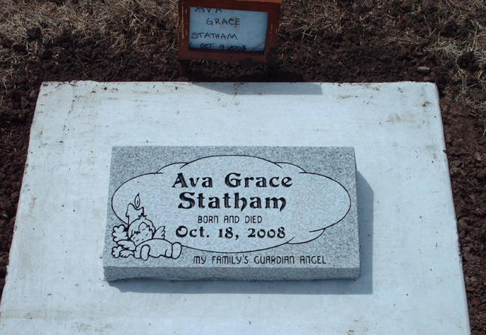 Gravestone plaque for Ava Grace Statham, with a teddy bear and flowers, dated Oct. 18, 2008