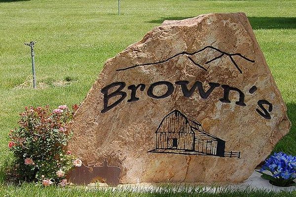 Brown's engraved on a large tan boulder in a grassy field