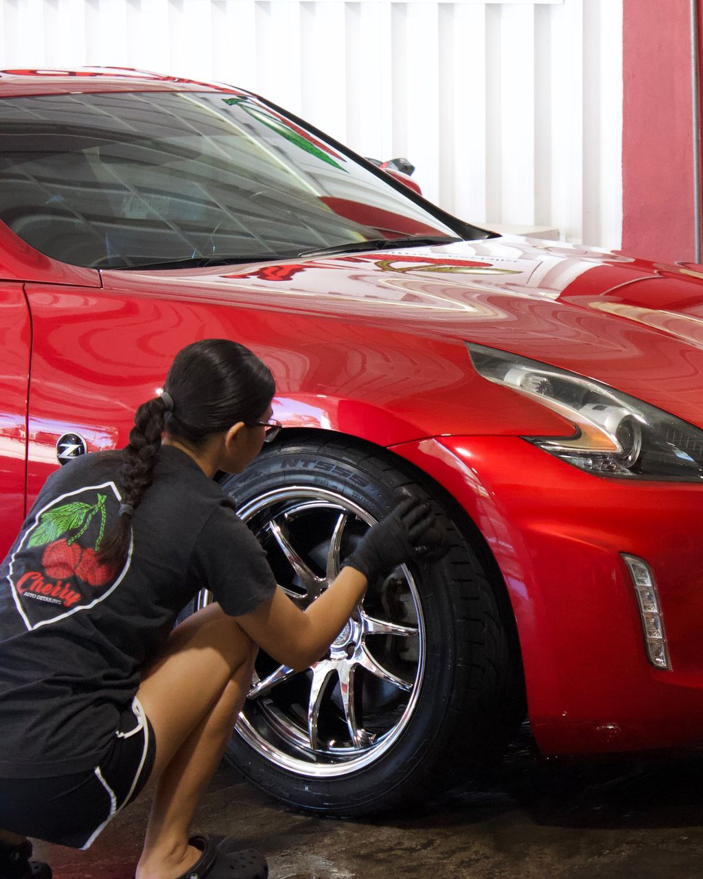A silver car is being washed with soap and water