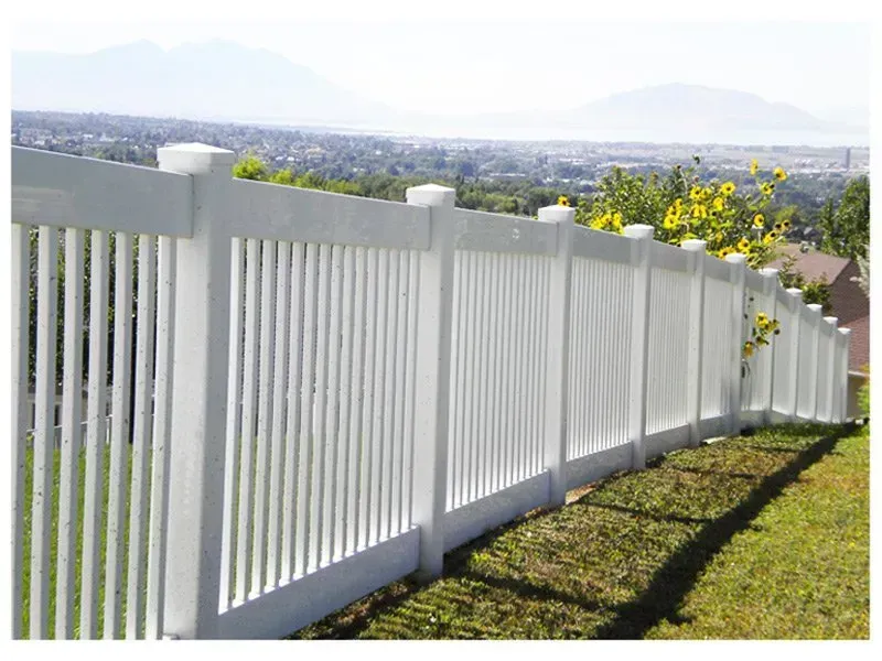 White picket fence overlooking a cityscape and mountains on a sunny day.