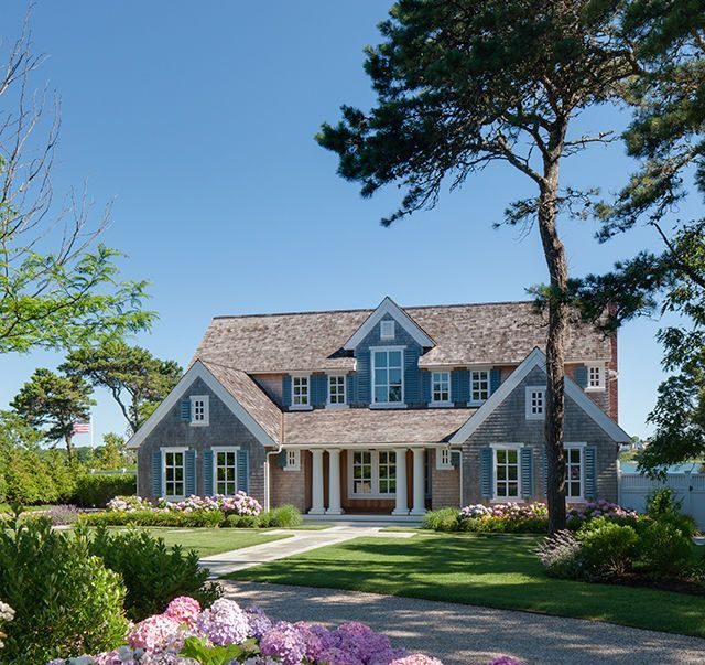Beachside house with pool, green lawn, and blue sky