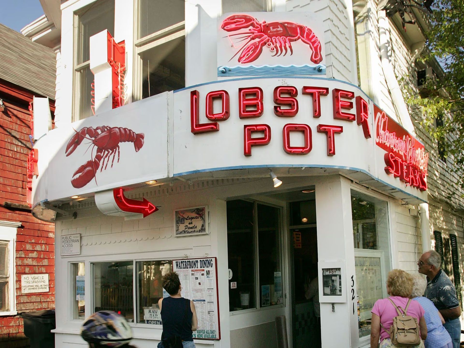 Lobster Pot restaurant storefront with red lobster signs and pedestrians outside