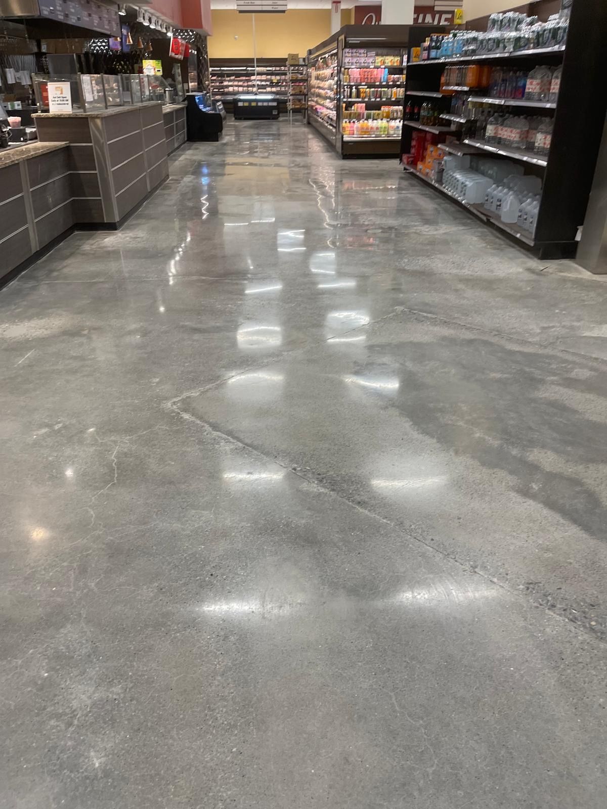 Grocery store aisle with polished concrete floor and stocked shelves on both sides