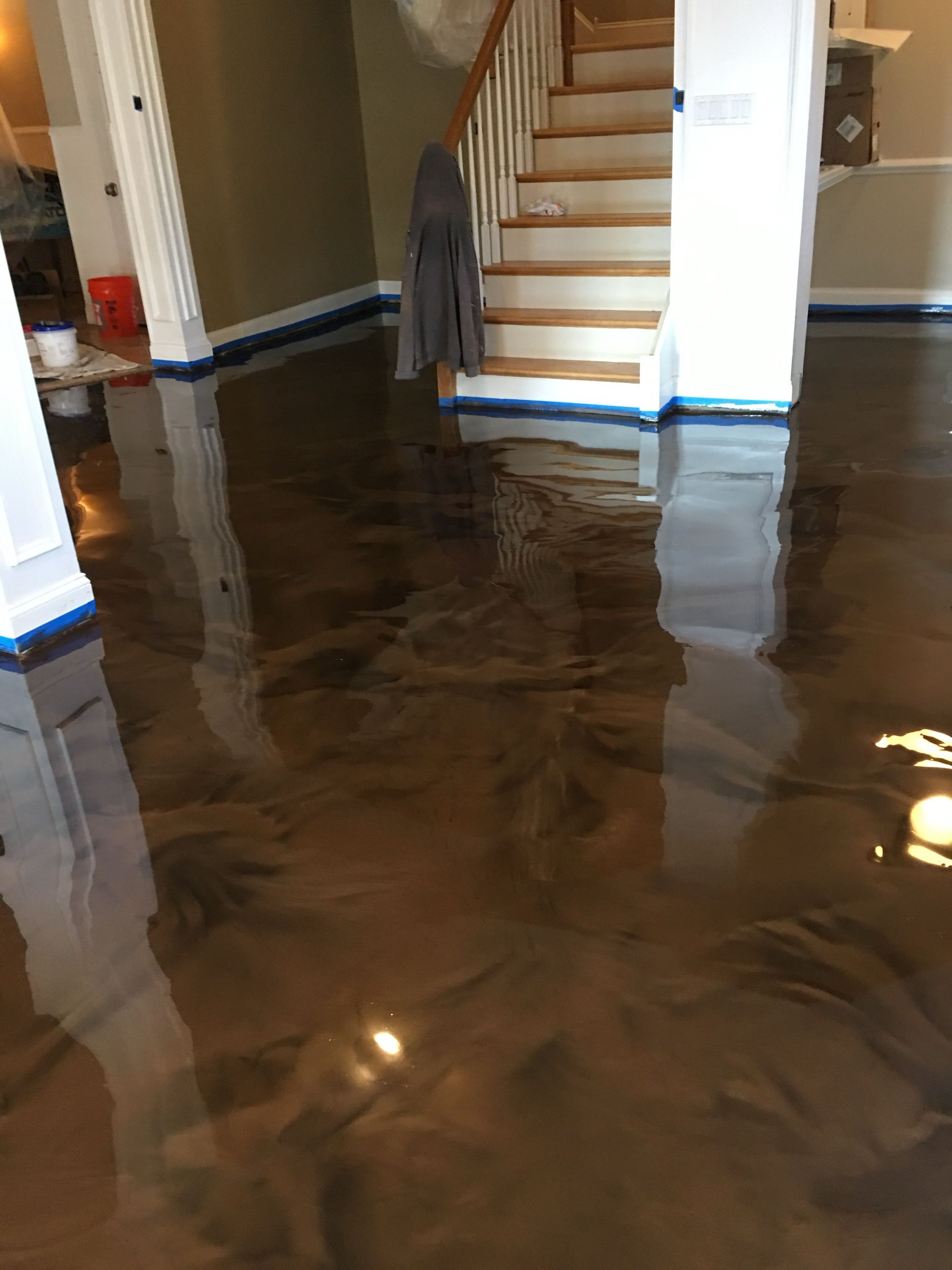 epoxy hallway with dark water reflecting stairs and walls in a home interior