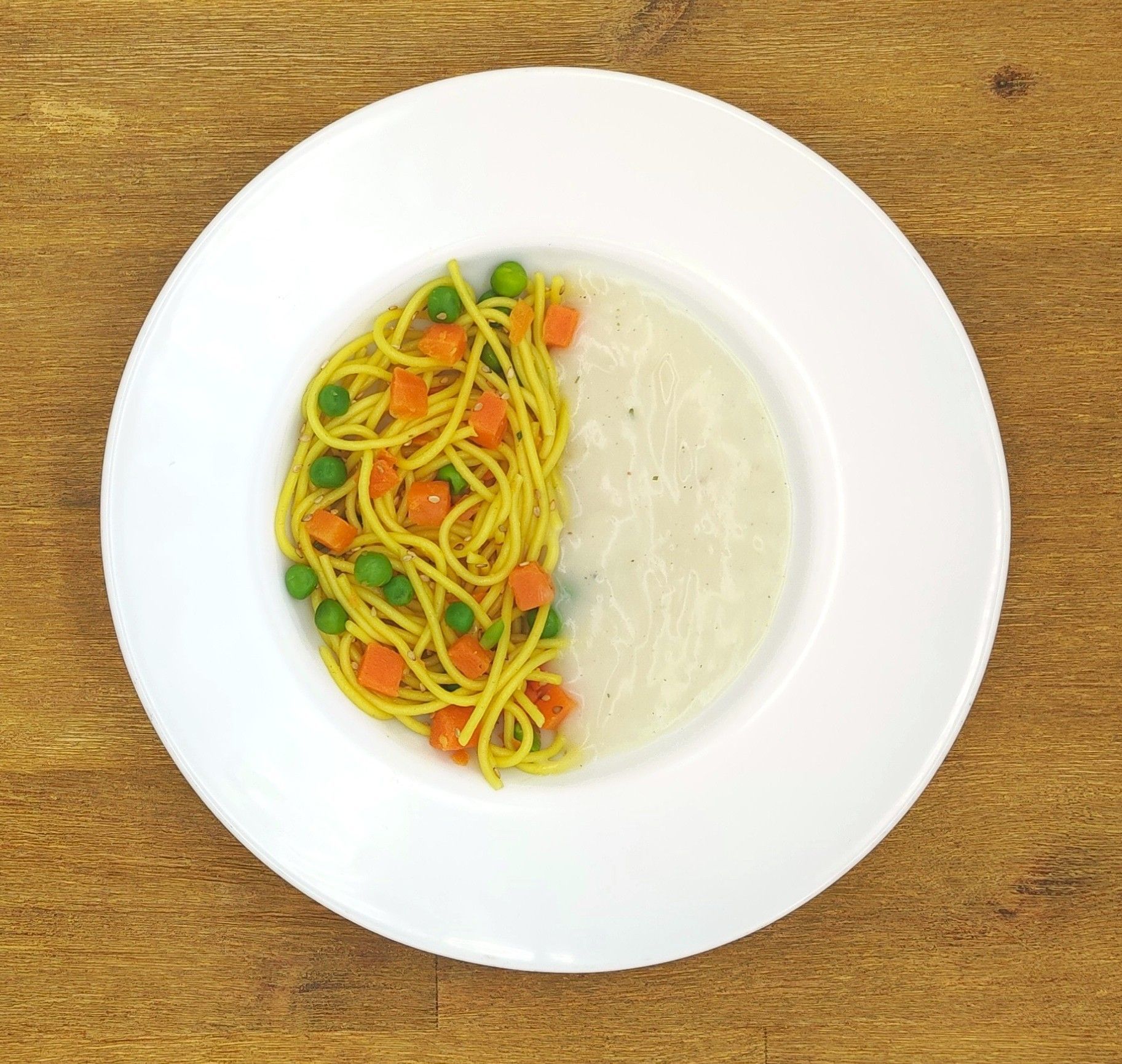 Weiße Schüssel mit Linsensuppe und Brot auf einer Holzoberfläche.