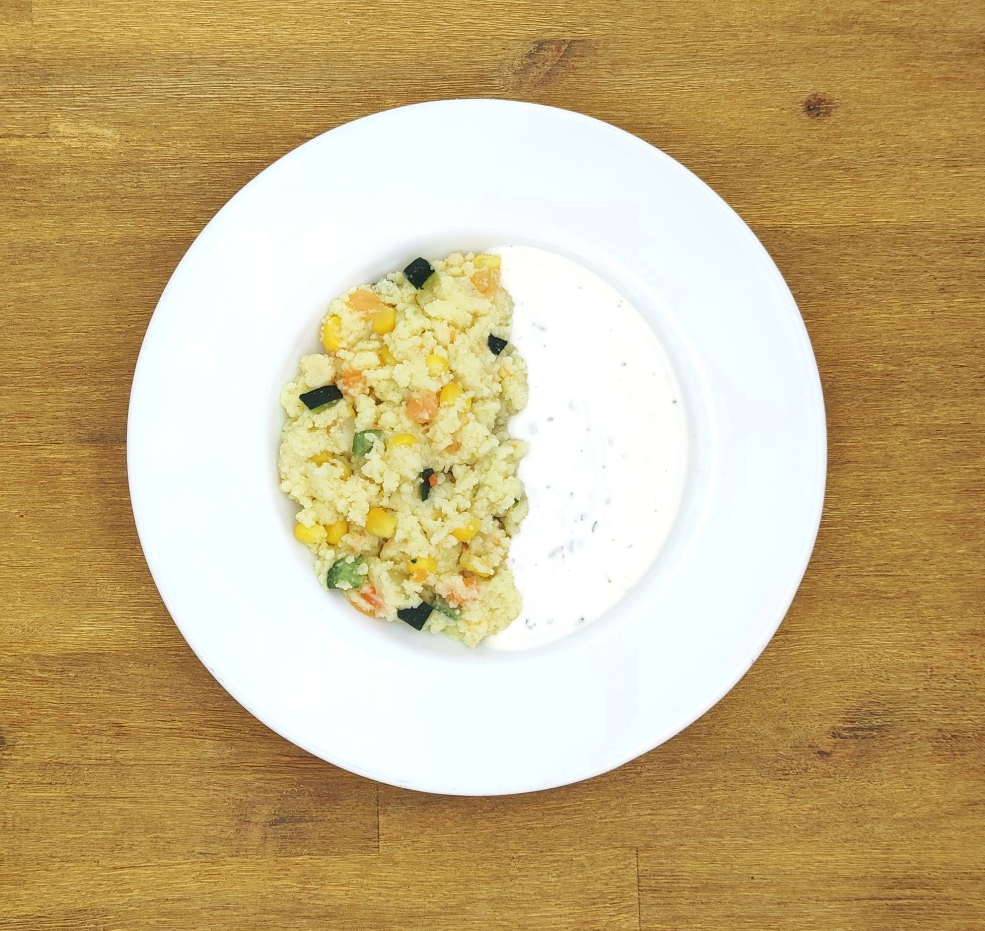 Weißer Teller mit Farfalle-Nudeln und Orangensauce, bestreut mit geriebenem Käse.