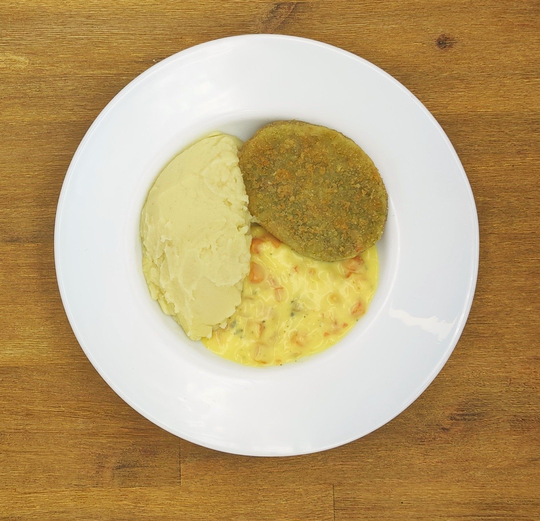 Weißer Teller mit Farfalle-Nudeln und Orangensauce, bestreut mit geriebenem Käse.