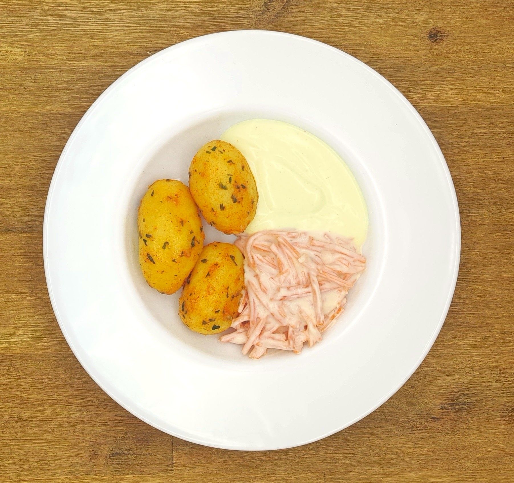 Weißer Teller mit Farfalle-Nudeln und Orangensauce, bestreut mit geriebenem Käse.