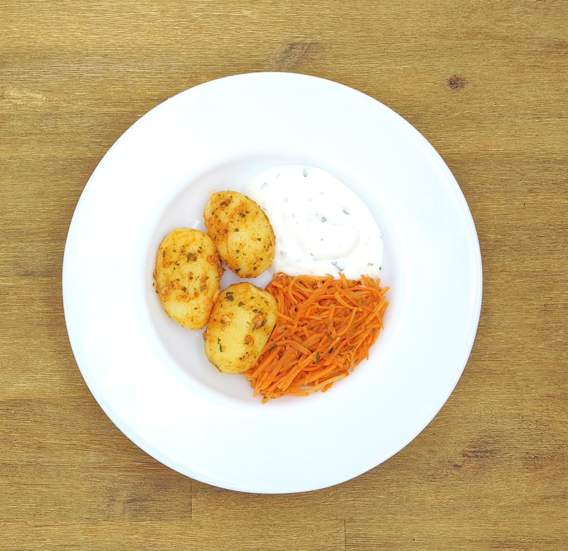 Weißer Teller mit Farfalle-Nudeln und Orangensauce, bestreut mit geriebenem Käse.