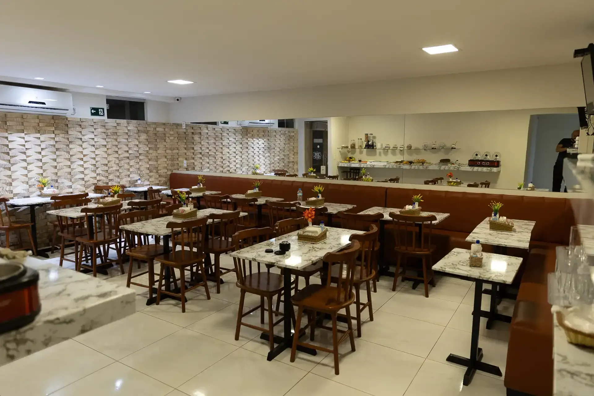 Há muitas mesas e cadeiras no restaurante.hotel-asa-branca