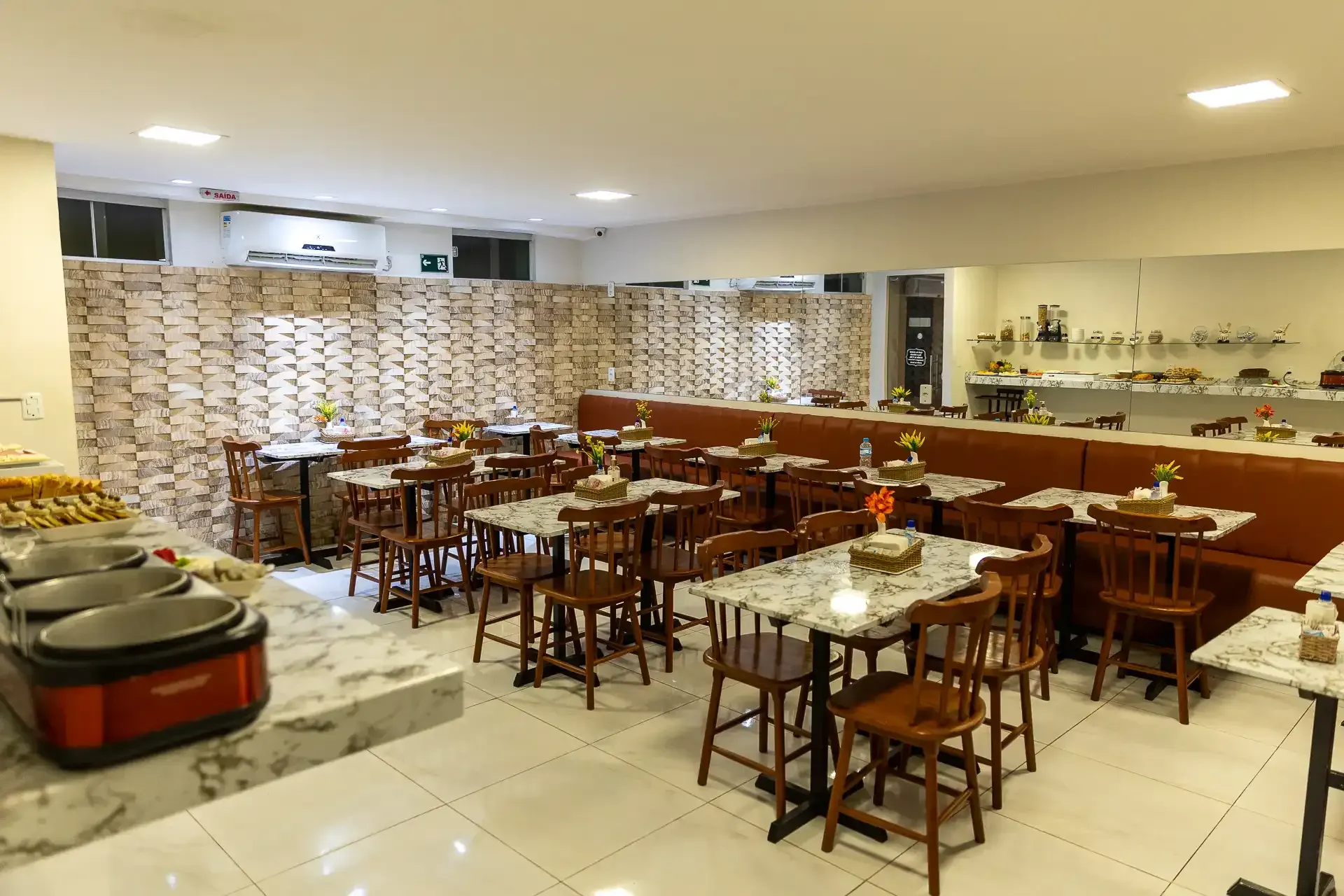 Há muitas mesas e cadeiras no restaurante.hotel-asa-branca