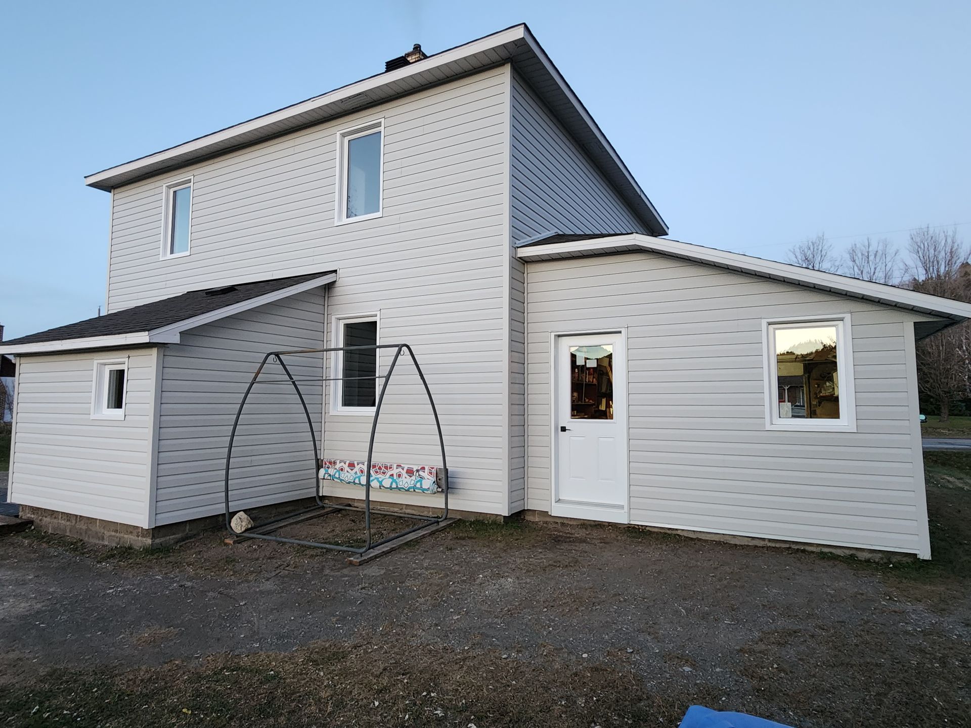Une maison blanche avec un hangar attenant