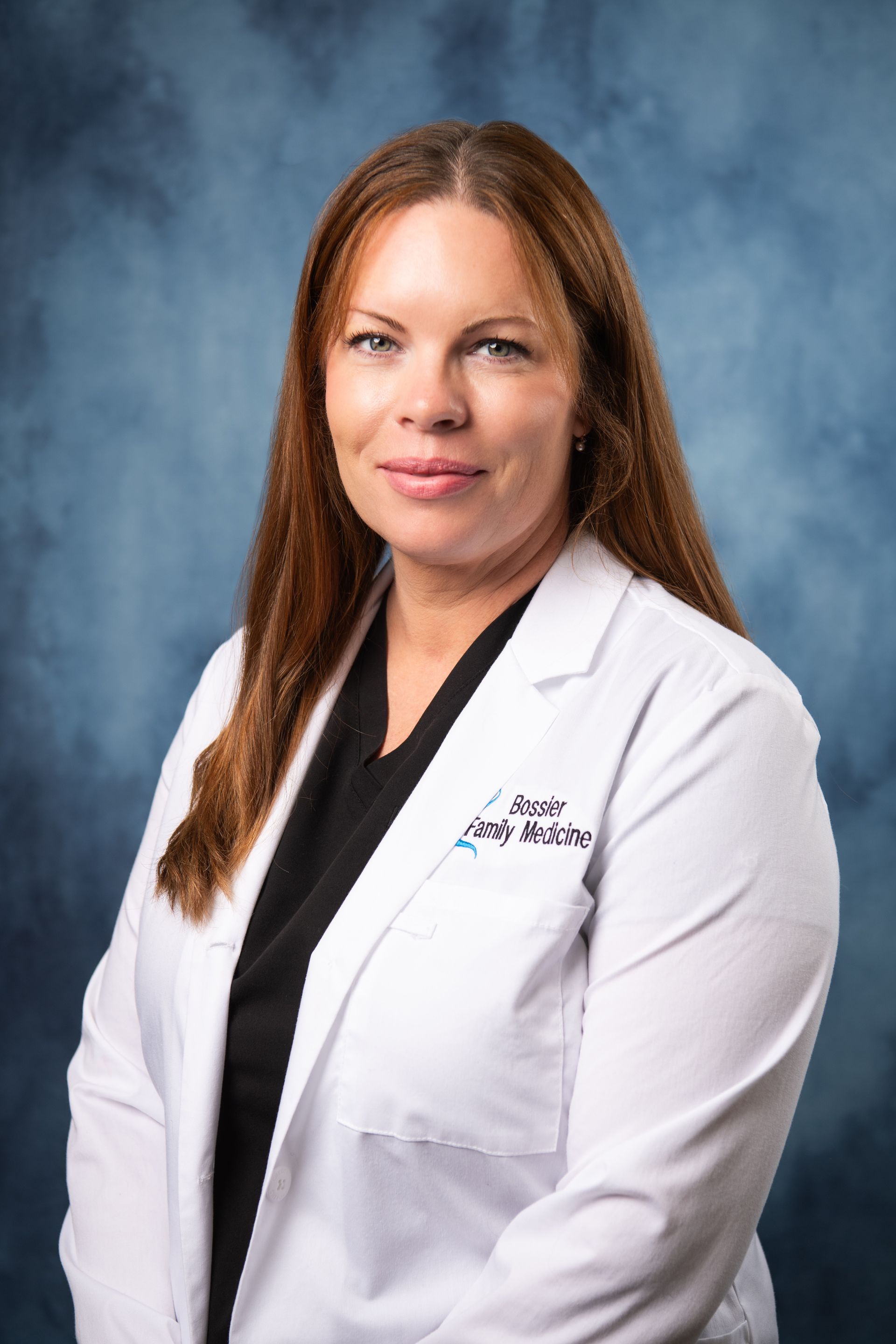 Portrait of a medical professional in a white coat against a blue studio backdrop