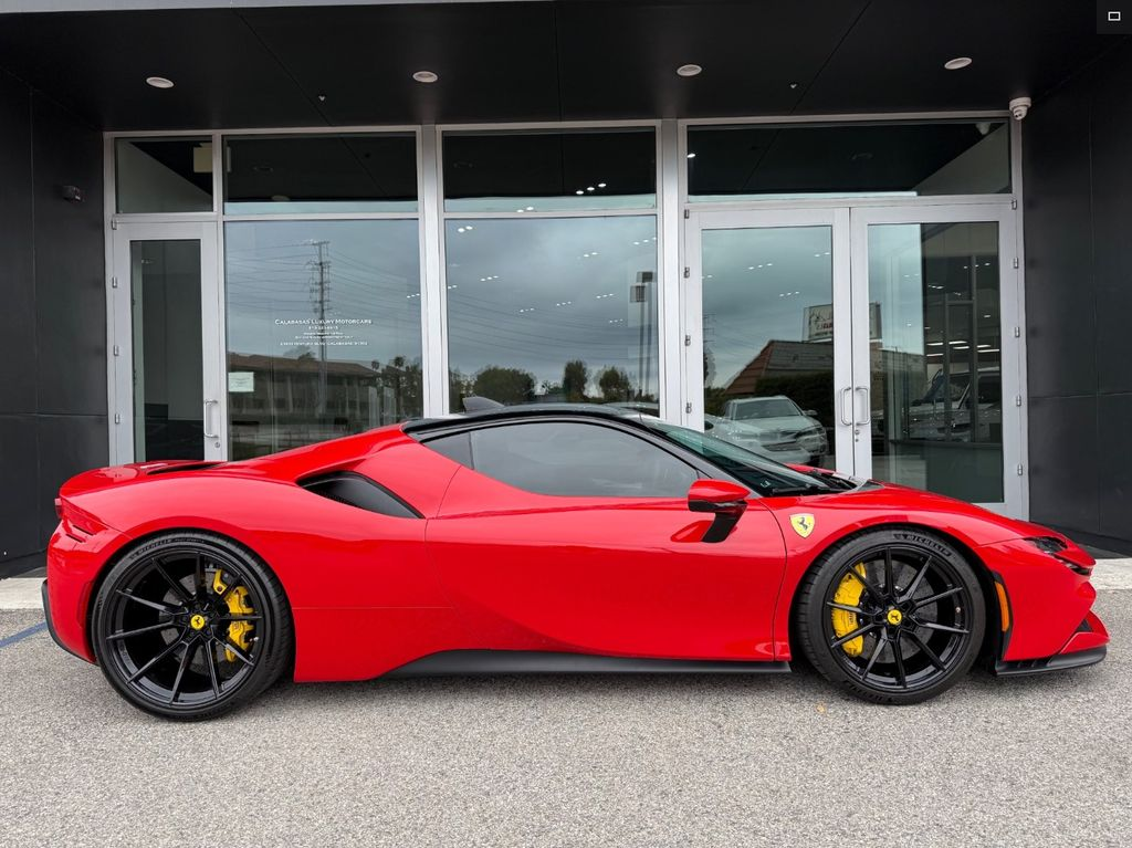Red Ferrari sports car parked in front of a building with large windows.