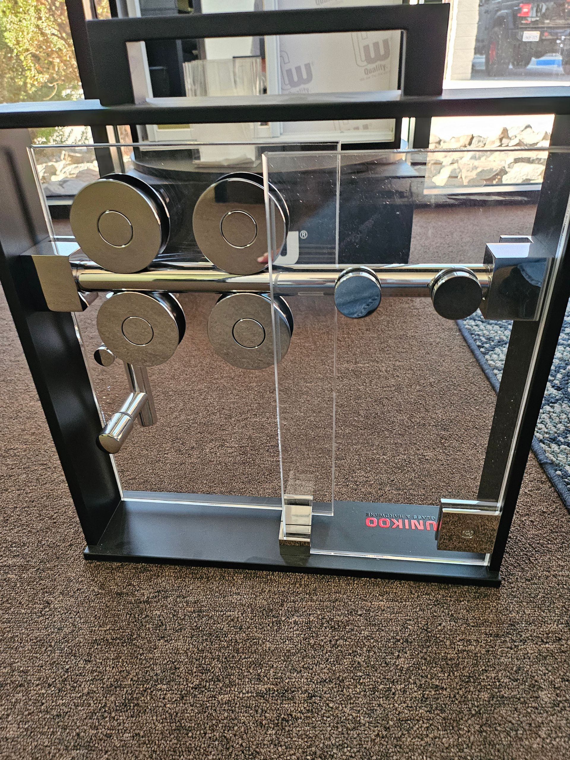Black frame with silver metal weights and pulleys, on brown carpet.
