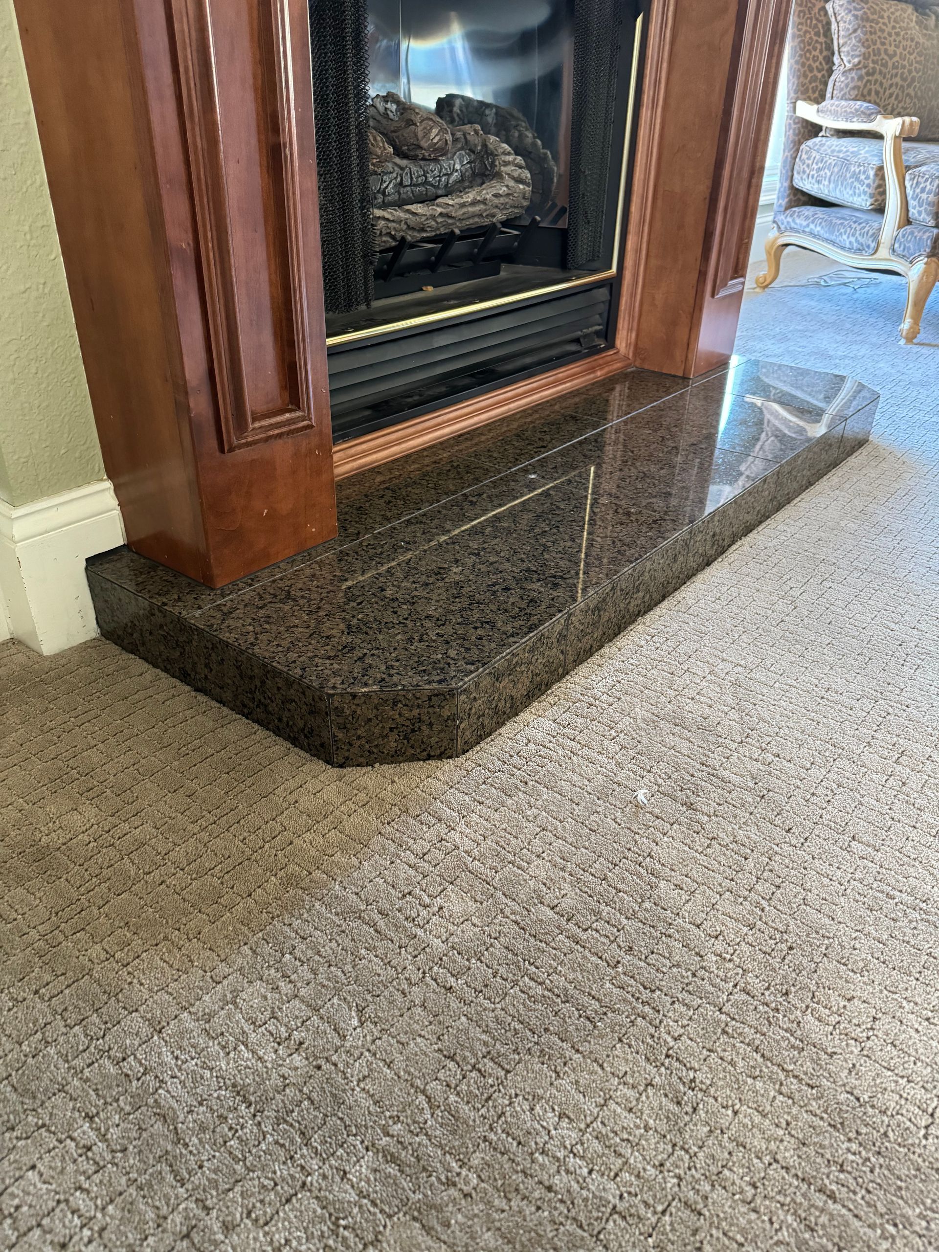 A living room with a fireplace and a carpeted floor.