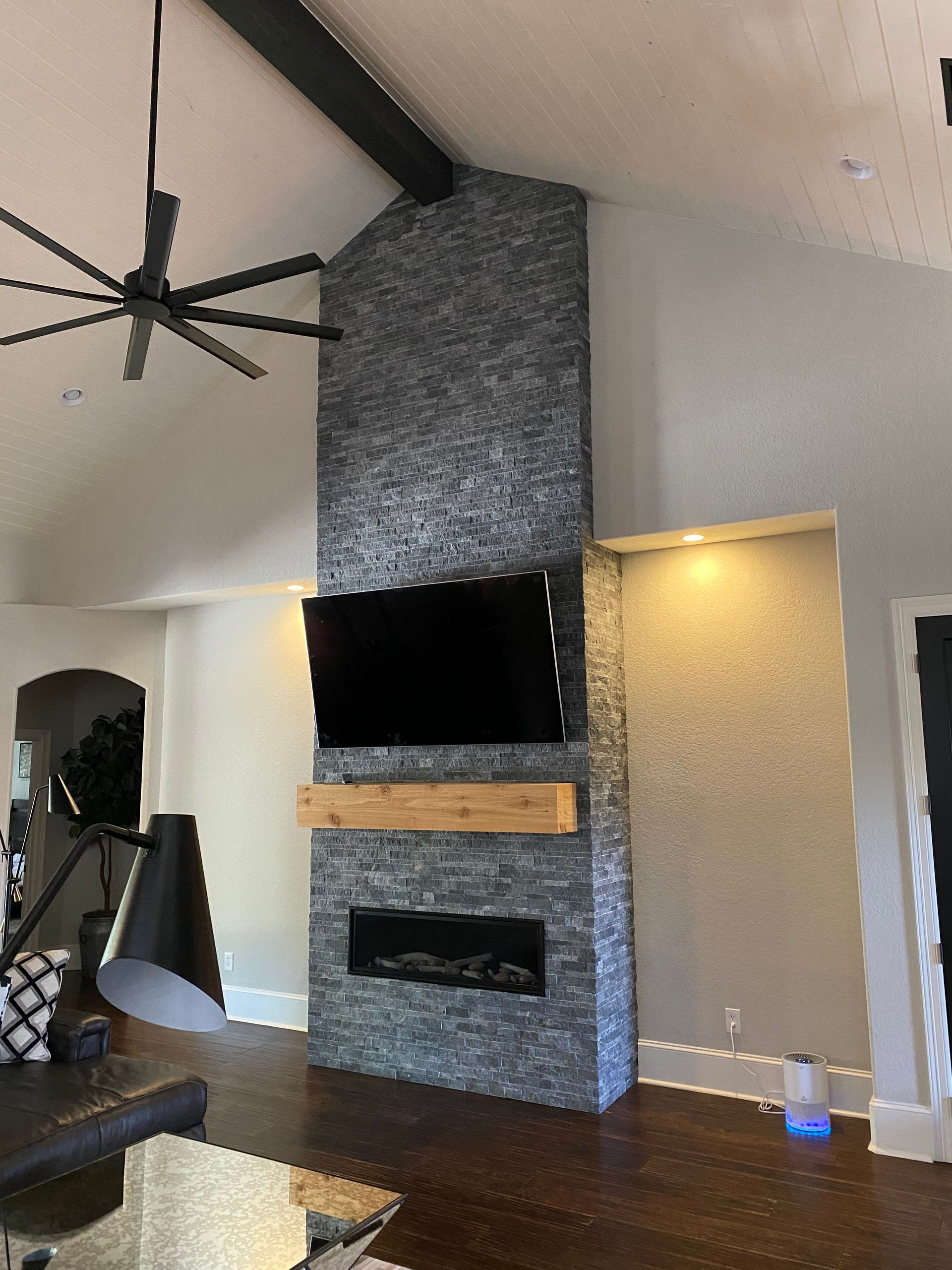 A living room with a fireplace and a flat screen tv on the wall.