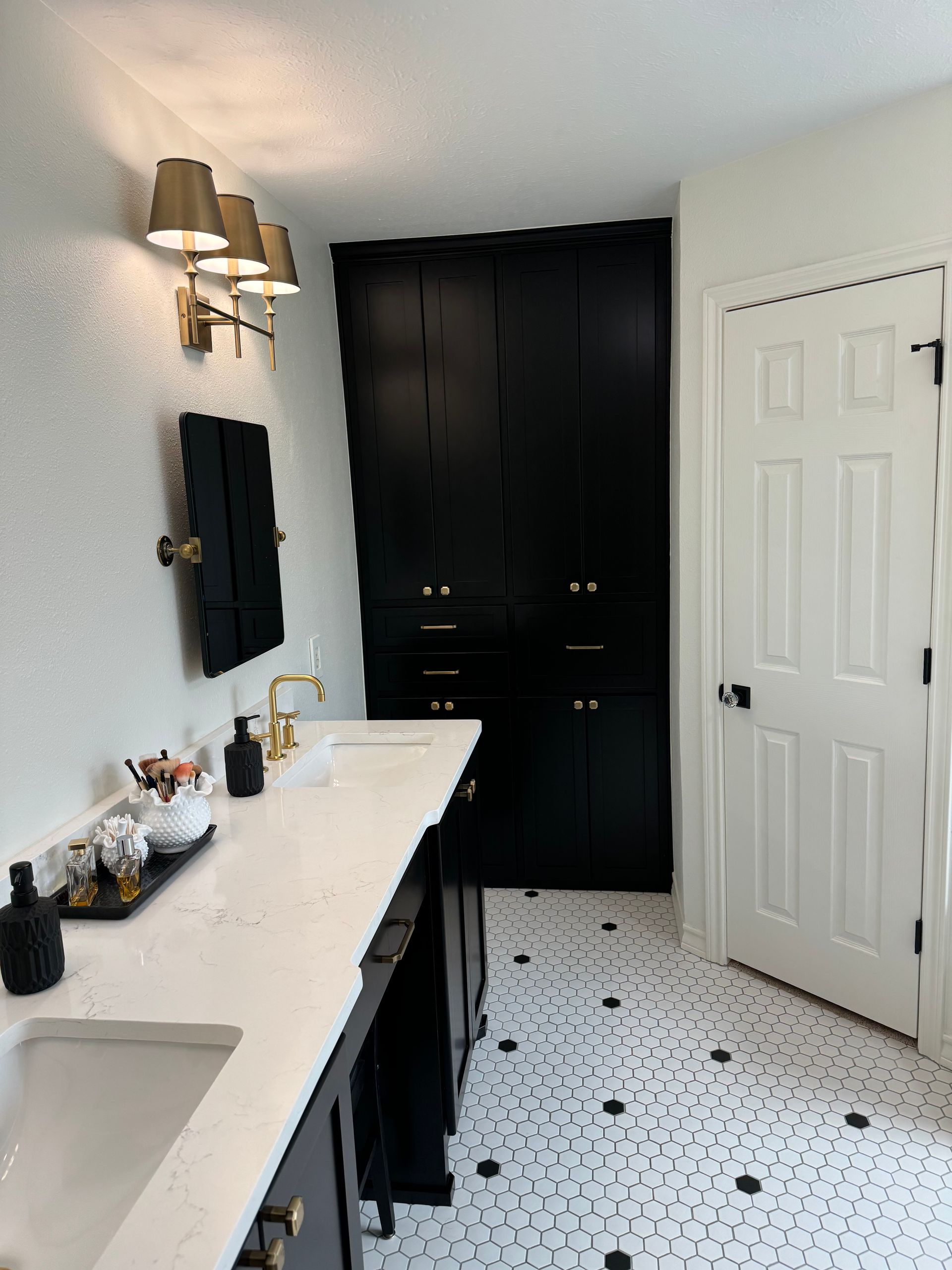 A bathroom with black cabinets and white counter tops