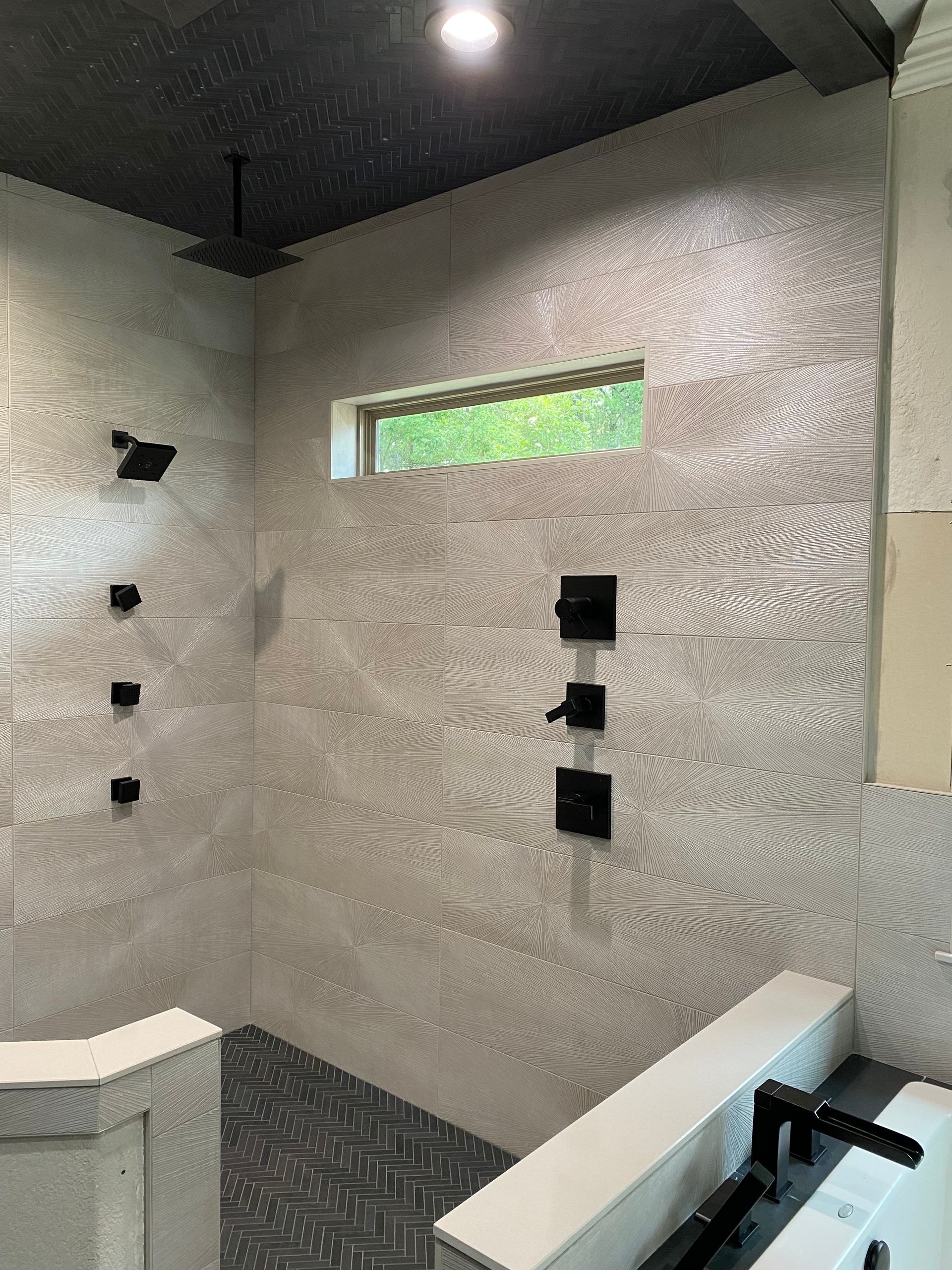 A bathroom with a walk in shower and a window.