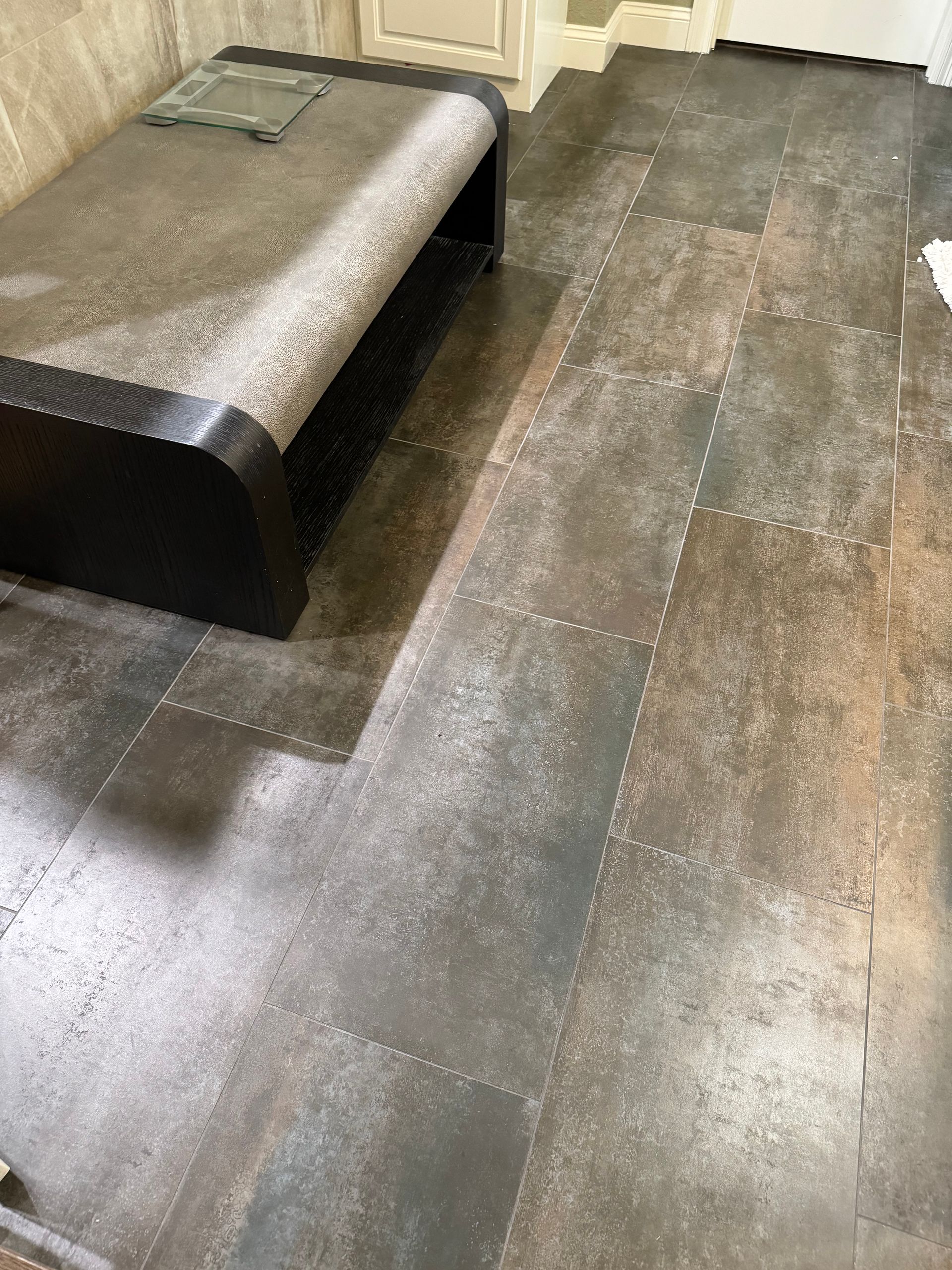 A bench is sitting on a tiled floor in a room.