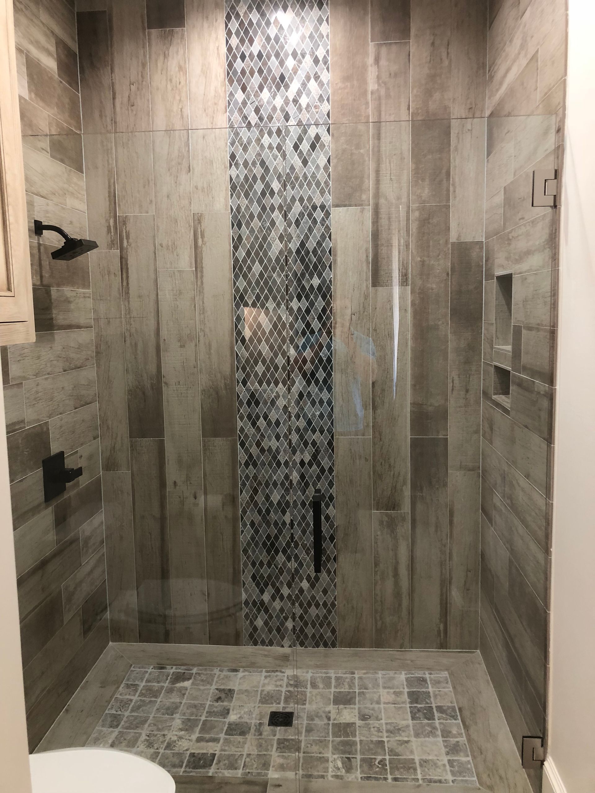 A bathroom with a walk in shower and a toilet.