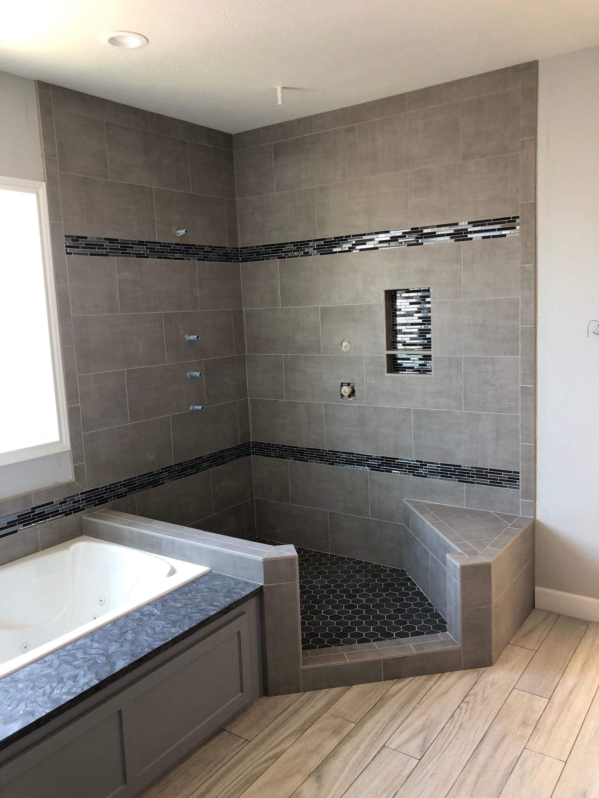 A bathroom with a tub and a walk in shower.