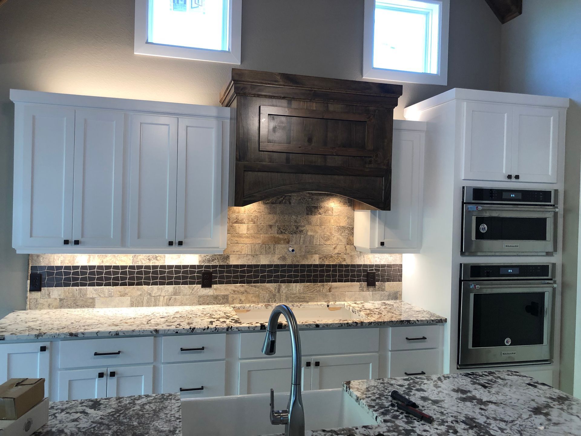 A kitchen with white cabinets and granite counter tops