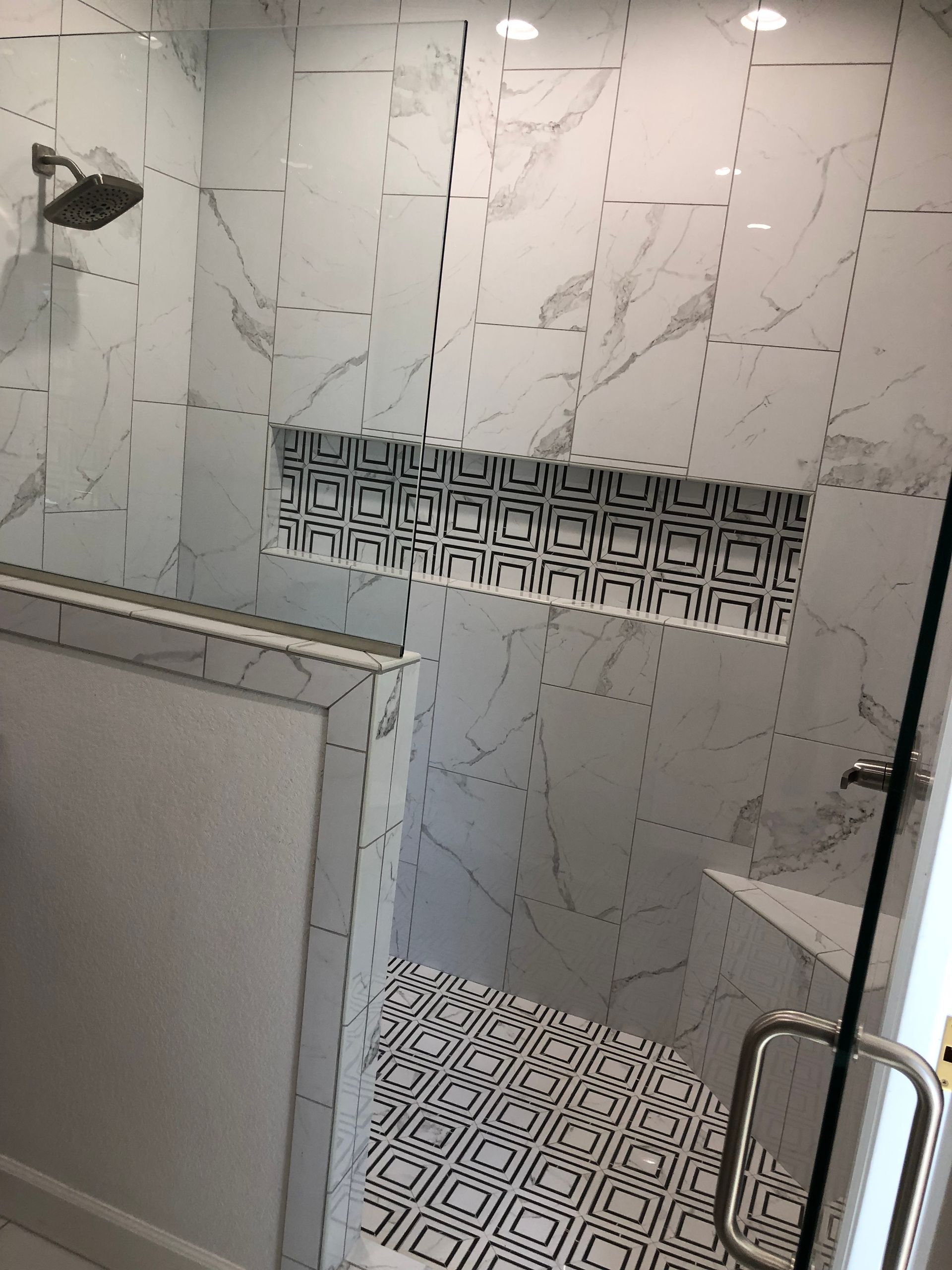 A bathroom with marble tiles and a walk in shower